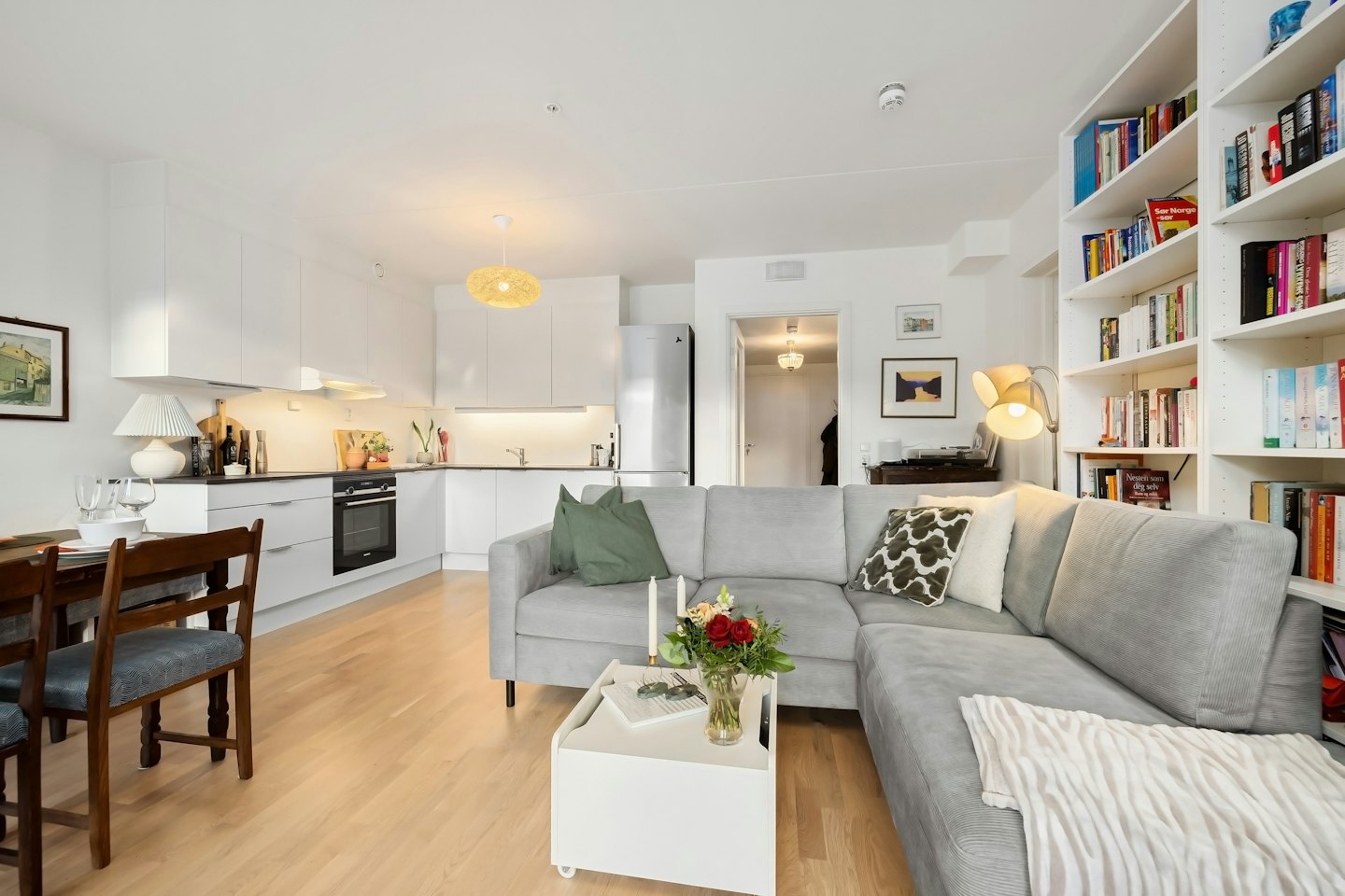 Nyitott terű apartman szürke kanapéval és modern konyhával.